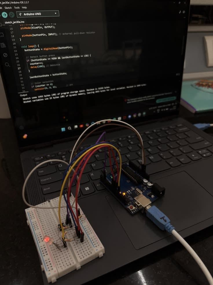 An Arduino board wired to a breadboard on a laptop running the sketch that drives it